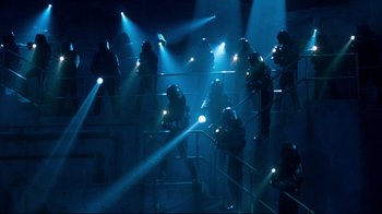 Movie still from “Moonwalker” (1988), directed by Jerry Kramer – A group of people standing on top of a set of stairs; Extreme Wide shot, High angle