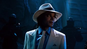 Movie still from “Moonwalker” (1988), directed by Jerry Kramer – A person wearing a suit and a white hat; Close Up shot, High angle