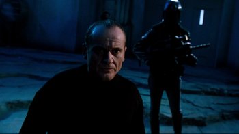 Movie still from “Moonwalker” (1988), directed by Jerry Kramer – A man in a black shirt is in the dark; Close Up shot, Low angle