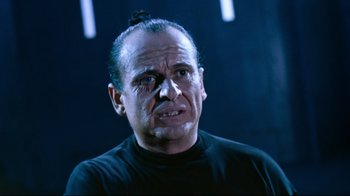 Movie still from “Moonwalker” (1988), directed by Jerry Kramer – An older man with a black shirt on; Close Up shot, Low angle