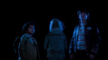 Movie still from “Moonwalker” (1988), directed by Jerry Kramer – A group of kids standing in the dark at night; Medium shot, Low angle