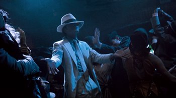 Movie still from “Moonwalker” (1988), directed by Jerry Kramer – A man in a white suit and a white hat; Medium shot, Low angle