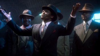 Movie still from “Moonwalker” (1988), directed by Jerry Kramer – A group of men in suits and fedora hats; Medium shot, Low angle