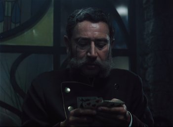 A man with a beard and mustache looking at his cell phone
