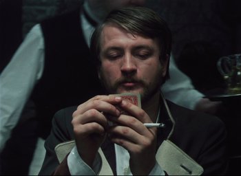 A man with a beard is eating a sandwich