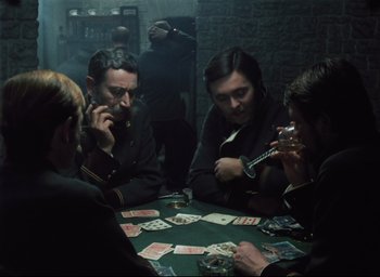 A group of people sitting at a table playing cards