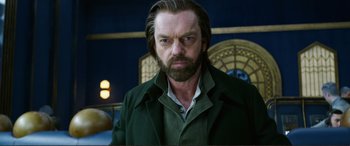 Movie still from “Mortal Engines” (2018), directed by Christian Rivers – A person with a beard wearing a green jacket; Close Up shot, Low angle