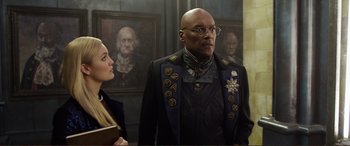 Movie still from “Mortal Engines” (2018), directed by Christian Rivers – A man and a woman standing next to each other in a room; Medium shot, Over the shoulder angle