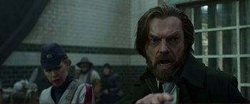 Movie still from “Mortal Engines” (2018), directed by Christian Rivers – A person with long hair and a goatee; Close Up shot, Over the shoulder angle