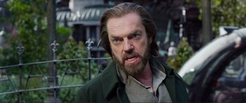 Movie still from “Mortal Engines” (2018), directed by Christian Rivers – A person with long hair and a beard; Close Up shot, Over the shoulder angle