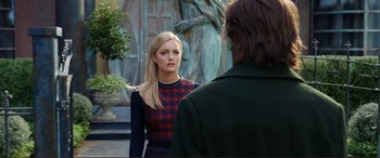 Movie still from “Mortal Engines” (2018), directed by Christian Rivers – A woman in a red and black dress is looking at a man in a black and red jacket; Medium shot, Over the shoulder angle