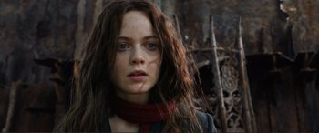 Movie still from “Mortal Engines” (2018), directed by Christian Rivers – A woman with long brown hair wearing a red scarf; Close Up shot, Low angle