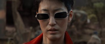 Movie still from “Mortal Engines” (2018), directed by Christian Rivers – A person wearing sunglasses and a red jacket; Extreme Close Up shot, Over the shoulder angle