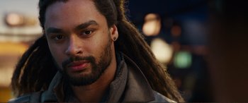 Movie still from “Mortal Engines” (2018), directed by Christian Rivers – A person with long dreadlocks; Close Up shot, Over the shoulder angle