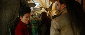 Movie still from “Mortal Engines” (2018), directed by Christian Rivers – A group of people standing under an umbrella; Close Up shot, Over the shoulder angle