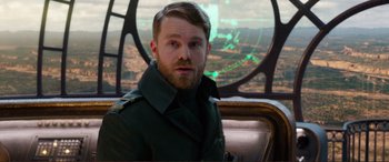 Movie still from “Mortal Engines” (2018), directed by Christian Rivers – A man with a beard is sitting in front of an airplane window; Close Up shot, Over the shoulder angle