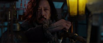 Movie still from “Mortal Engines” (2018), directed by Christian Rivers – A person with long black hair holding a gun; Close Up shot, Low angle