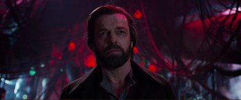 Movie still from “Mortal Engines” (2018), directed by Christian Rivers – A man with long hair and a goatee is looking at the camera; Close Up shot, Low angle