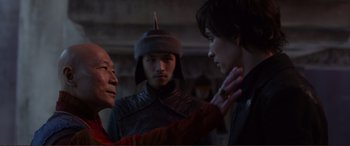 Movie still from “Mortal Engines” (2018), directed by Christian Rivers – A group of men standing next to each other; Medium shot, Over the shoulder angle