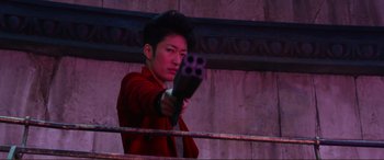 Movie still from “Mortal Engines” (2018), directed by Christian Rivers – A man holding a gun in his hand; Medium shot, Over the shoulder angle