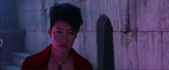 Movie still from “Mortal Engines” (2018), directed by Christian Rivers – A young man with a red shirt and a black necklace; Close Up shot, Low angle