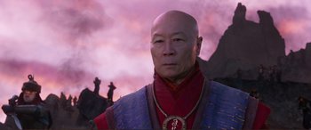 Movie still from “Mortal Engines” (2018), directed by Christian Rivers – An older man wearing a red and blue outfit; Close Up shot, Low angle