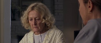 Movie still from “Mother and Child” (2009), directed by Rodrigo García – An older woman with blonde curly hair looking down; Close Up shot, Over the shoulder angle