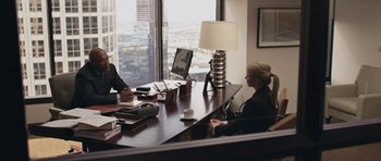 Movie still from “Mother and Child” (2009), directed by Rodrigo García – Two people sitting at a desk in front of a large window; Wide shot, Over the shoulder angle