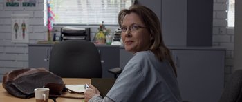 Movie still from “Mother and Child” (2009), directed by Rodrigo García – A woman sitting at a table in an office setting; Close Up shot, Over the shoulder angle