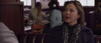 Movie still from “Mother and Child” (2009), directed by Rodrigo García – A woman sitting at a table in front of a group of people; Close Up shot, Over the shoulder angle