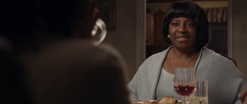 Movie still from “Mother and Child” (2009), directed by Rodrigo García – A woman sitting at a table with a plate of food in front of her; Close Up shot, Over the shoulder angle