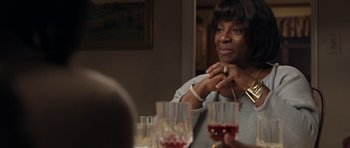 Movie still from “Mother and Child” (2009), directed by Rodrigo García – A woman sitting in front of a glass of wine; Close Up shot, Over the shoulder angle