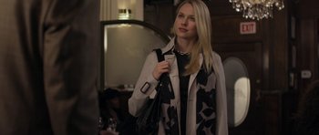 Movie still from “Mother and Child” (2009), directed by Rodrigo García – A beautiful blond woman holding a black and white purse; Medium shot, Over the shoulder angle