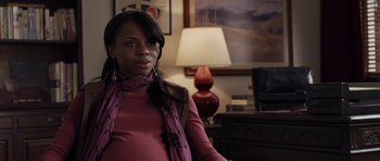 Movie still from “Mother and Child” (2009), directed by Rodrigo García – A black woman wearing a pink shirt and a purple scarf; Medium shot, Over the shoulder angle