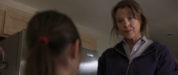 Movie still from “Mother and Child” (2009), directed by Rodrigo García – A woman standing in front of a mirror in a room; Close Up shot, Over the shoulder angle