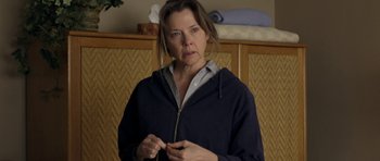 Movie still from “Mother and Child” (2009), directed by Rodrigo García – A woman standing in front of a wooden cabinet; Close Up shot, Over the shoulder angle