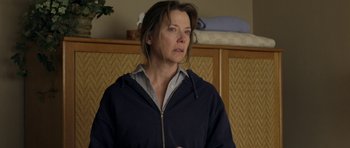 Movie still from “Mother and Child” (2009), directed by Rodrigo García – A woman standing in front of a bed looking to her left; Medium shot, Over the shoulder angle