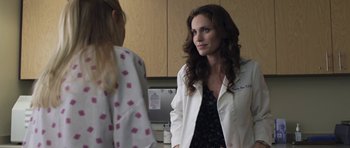 Movie still from “Mother and Child” (2009), directed by Rodrigo García – A woman wearing a white lab coat talking to a girl; Medium shot, Over the shoulder angle