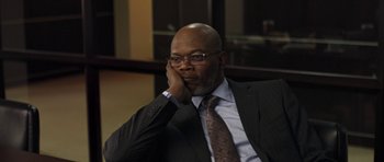 Movie still from “Mother and Child” (2009), directed by Rodrigo García – A man in a suit and tie sitting in front of a window; Close Up shot, High angle