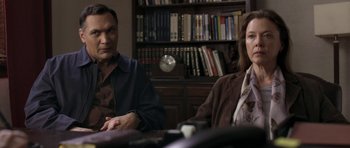 Movie still from “Mother and Child” (2009), directed by Rodrigo García – A man and a woman sitting in front of a book shelf; Medium shot, Over the shoulder angle