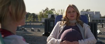 Movie still from “Mother and Child” (2009), directed by Rodrigo García – A woman sitting in a chair holding her stomach; Medium shot, Over the shoulder angle