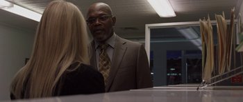 Movie still from “Mother and Child” (2009), directed by Rodrigo García – A man in a suit and tie talking to a woman in front of a mirror; Medium shot, Over the shoulder angle