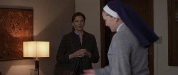 Movie still from “Mother and Child” (2009), directed by Rodrigo García – A woman standing in front of a mirror talking to a nun; Medium shot, Over the shoulder angle