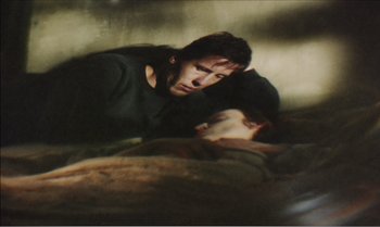 Movie still from “Mother and Son” (1997), directed by Aleksandr Sokurov – A man and a woman laying on the ground; Medium shot, Overhead angle