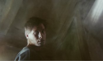 Movie still from “Mother and Son” (1997), directed by Aleksandr Sokurov – A young man is looking into the distance; Close Up shot, Low angle