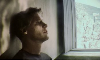 Movie still from “Mother and Son” (1997), directed by Aleksandr Sokurov – A man looking out of a window with his eyes wide open; Close Up shot, Low angle