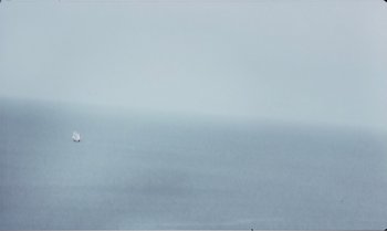 Movie still from “Mother and Son” (1997), directed by Aleksandr Sokurov – A boat sailing on a large body of water; Extreme Wide shot, Low angle