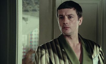 Movie still from “Mr. Klein” (1976), directed by Joseph Losey – A person wearing a robe in a room; Close Up shot, Over the shoulder angle