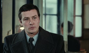 Movie still from “Mr. Klein” (1976), directed by Joseph Losey – A person wearing a suit and tie; Close Up shot, Over the shoulder angle