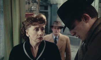 Movie still from “Mr. Klein” (1976), directed by Joseph Losey – An older woman and a man in a suit and hat; Close Up shot, Over the shoulder angle